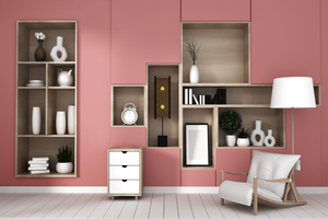A beautiful room with pink colors and in-built shelves with white decorative elements and white leather armchair in a minimalistic Nordic style 